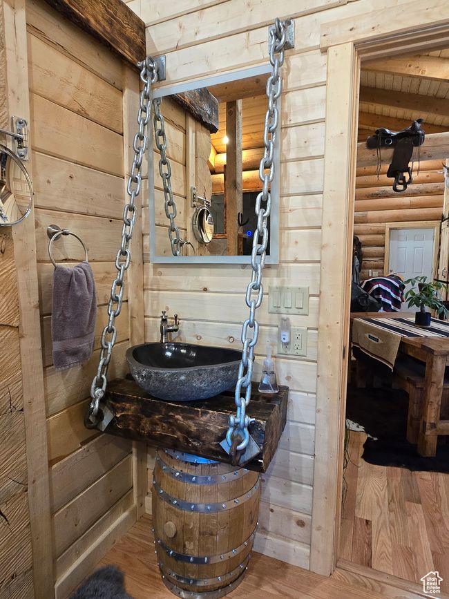 Bathroom with wood finished floors, rustic walls, and a sink | Image 111