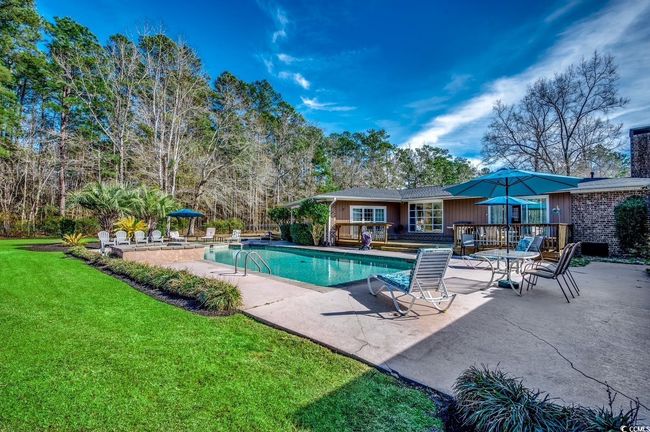 Swimming pool featuring a yard, a patio, and a wooden deck | Image 31