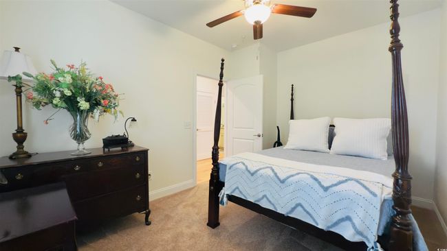 Bedroom with light carpet and a ceiling fan | Image 10