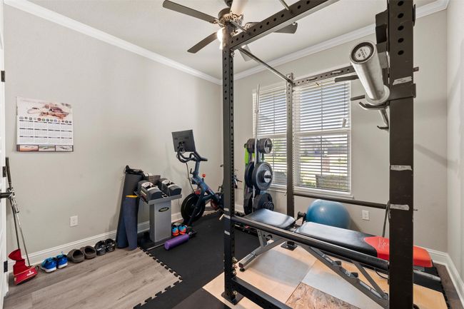 Exercise room with ornamental molding, baseboards, and a ceiling fan | Image 16