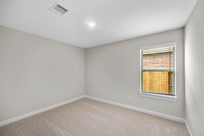 Step into the secondary bedroom, where a window allows natural light to fill the space, creating a bright and inviting atmosphere. Whether it serves as a child's bedroom or a peaceful retreat for guests, this room offers comfort and charm. | Image 7