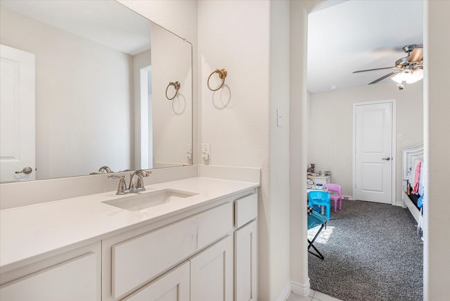 Ensuite bathroom with ceiling fan, baseboards, connected bathroom, and vanity | Image 23