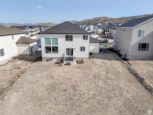 Back of house with entry steps, a mountain view, stucco siding, and a residential view | Image 38