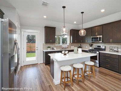 Kitchen with appliances with stainless steel finishes, light hardwood / wood-style flooring, and dark brown cabinetry | Image 2