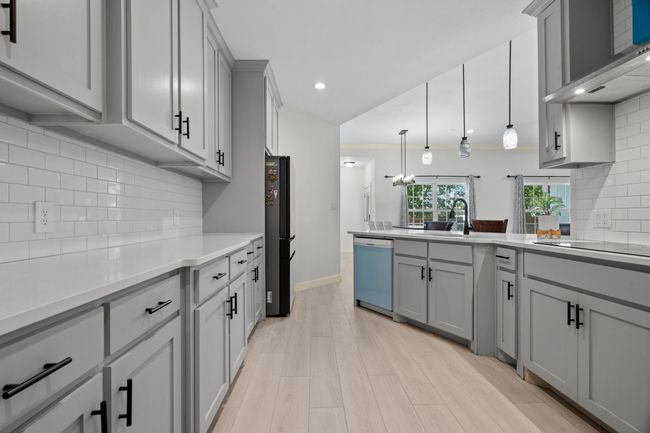 Kitchen featuring gray cabinetry, black appliances, a peninsula, light countertops, and recessed lighting | Image 20