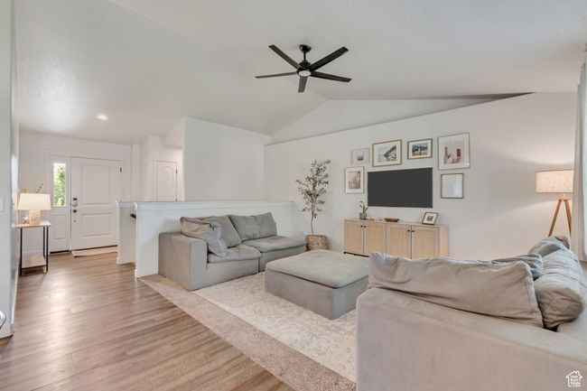 Living room featuring ceiling fan, light wood-type flooring, lofted ceiling, and recessed lighting | Image 4