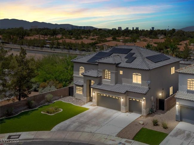 Mediterranean / spanish home with a garage, concrete driveway, stucco siding, roof mounted solar panels, and a tiled roof | Image 4