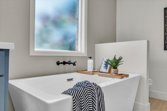 Bathroom featuring toilet, a soaking tub, and wood finished floors | Image 40
