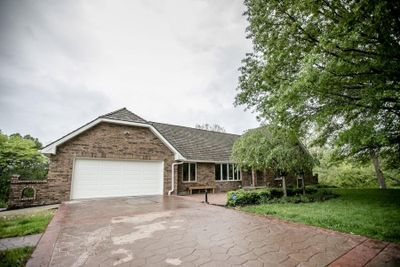 Ranch-style house featuring a front yard and a garage | Image 1