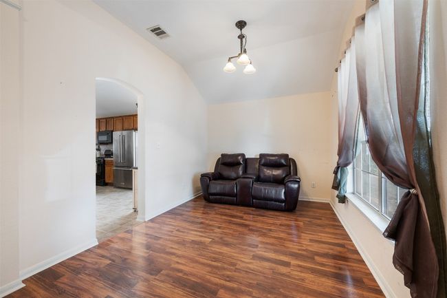 Sitting room with arched walkways, visible vents, lofted ceiling, and wood finished floors | Image 10