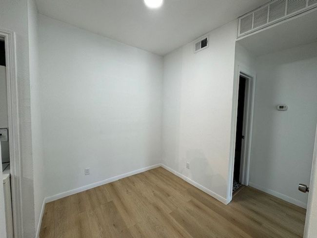 Spare room featuring light wood-style flooring and baseboards | Image 9