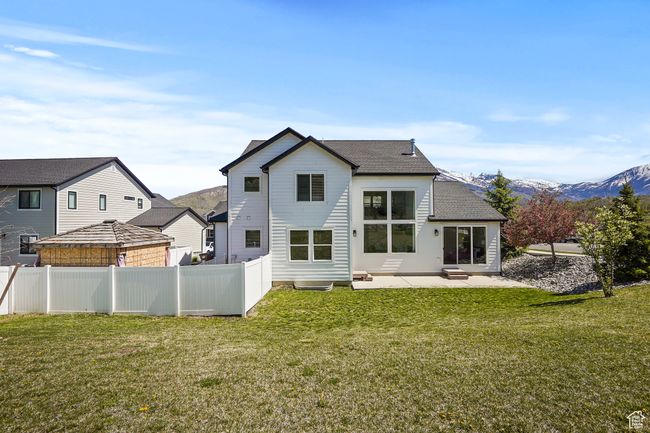Rear view of house featuring a patio, a fenced backyard, roof with shingles, and a mountain view | Image 35