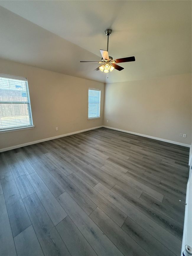 Empty room featuring dark wood-type flooring, ceiling fan, and baseboards | Image 9