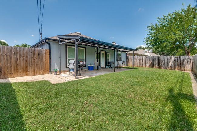 Rear view of house with a fenced backyard and a patio | Image 24