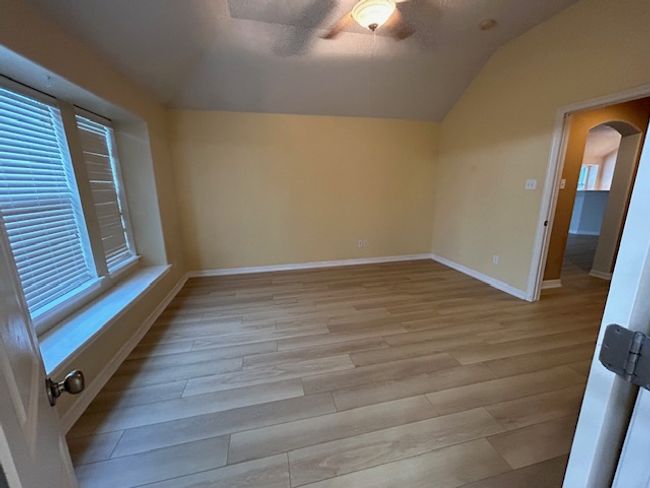 Empty room with light wood-style floors, lofted ceiling, and recessed lighting | Image 14