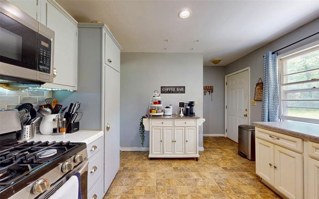 Kitchen featuring appliances with stainless steel finishes, stone finish flooring, baseboards, light countertops, and recessed lighting | Image 21