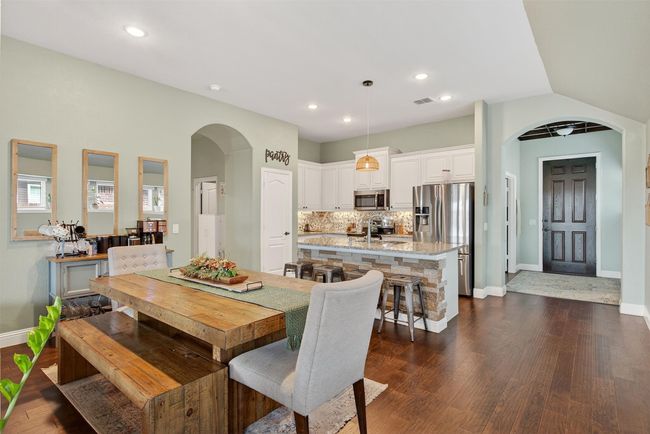 Dining area featuring arched walkways, dark wood-style floors, and recessed lighting | Image 17