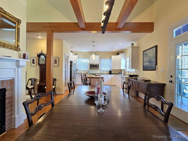Dining area featuring beam ceiling, a healthy amount of sunlight, baseboards, and a brick fireplace | Image 16