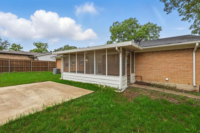 Rear view of property with brick siding, a patio area, a sunroom, and central air condition unit | Image 19