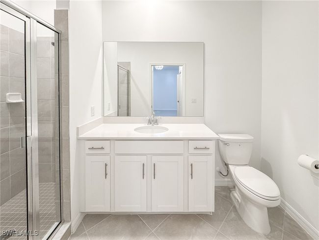 Full bathroom with a stall shower, baseboards, toilet, and vanity | Image 26