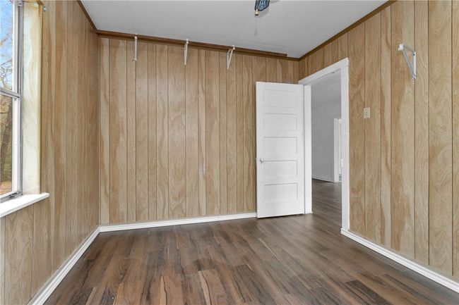 Unfurnished room featuring wooden walls and wood finished floors | Image 24