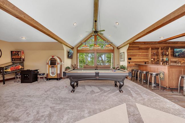 Recreation zone featuring a stylish bar and room for pool, darts, or arcade games. | Image 68