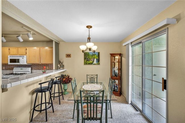 Dining room with a chandelier and light carpet | Image 24