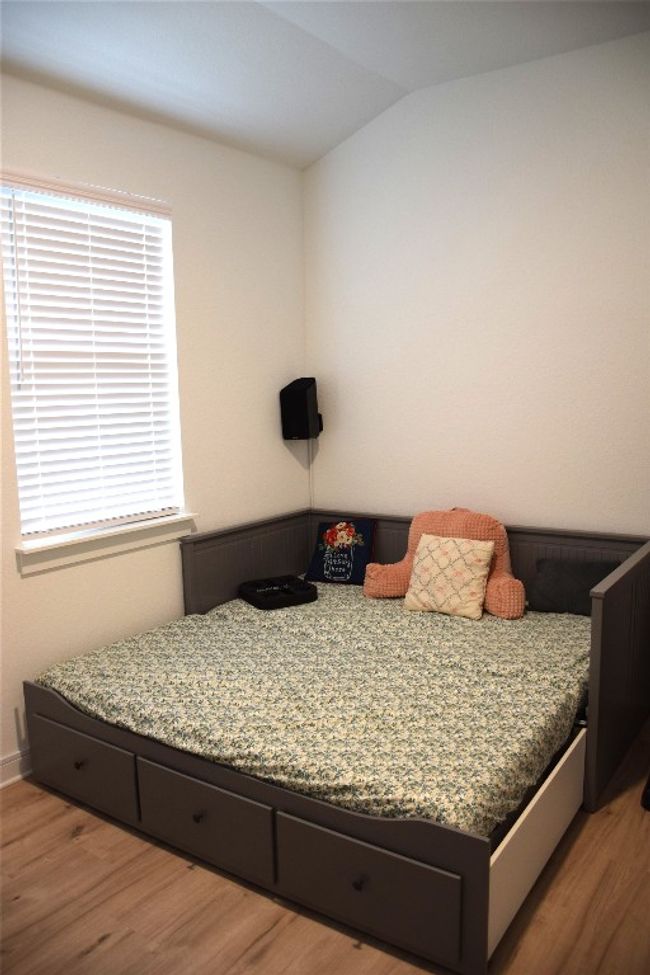 Bedroom featuring wood finished floors, vaulted ceiling, and baseboards | Image 25