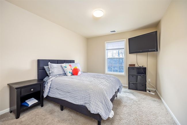 Bedroom featuring light carpet, visible vents, and baseboards | Image 15