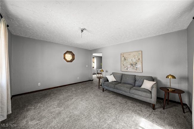 Carpeted living room with baseboards and a textured ceiling | Image 10