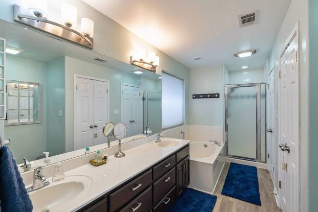 Full bathroom featuring wood finished floors, visible vents, and a sink | Image 9