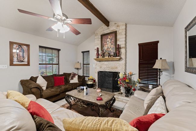 Living room featuring a ceiling fan and a stone fireplace | Image 6