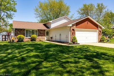 Ranch-style home featuring a garage and a front lawn | Image 2