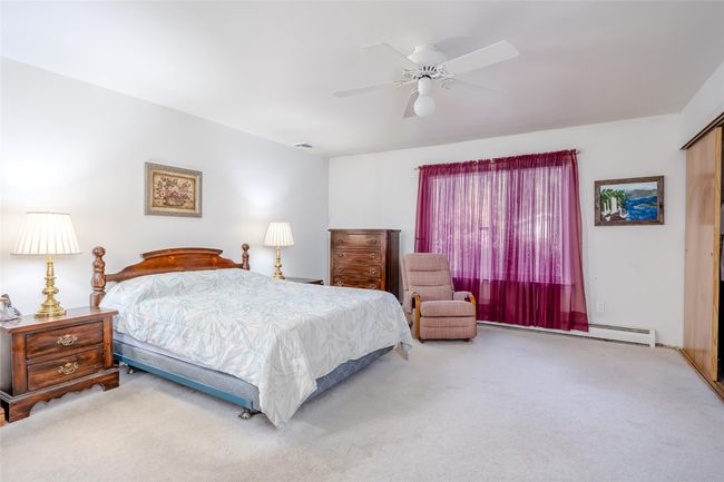 Carpeted bedroom featuring ceiling fan and a baseboard radiator | Image 22