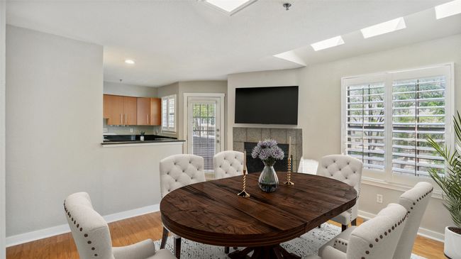 Dining room with a skylight, baseboards, a fireplace, light wood-type flooring, and recessed lighting | Image 5