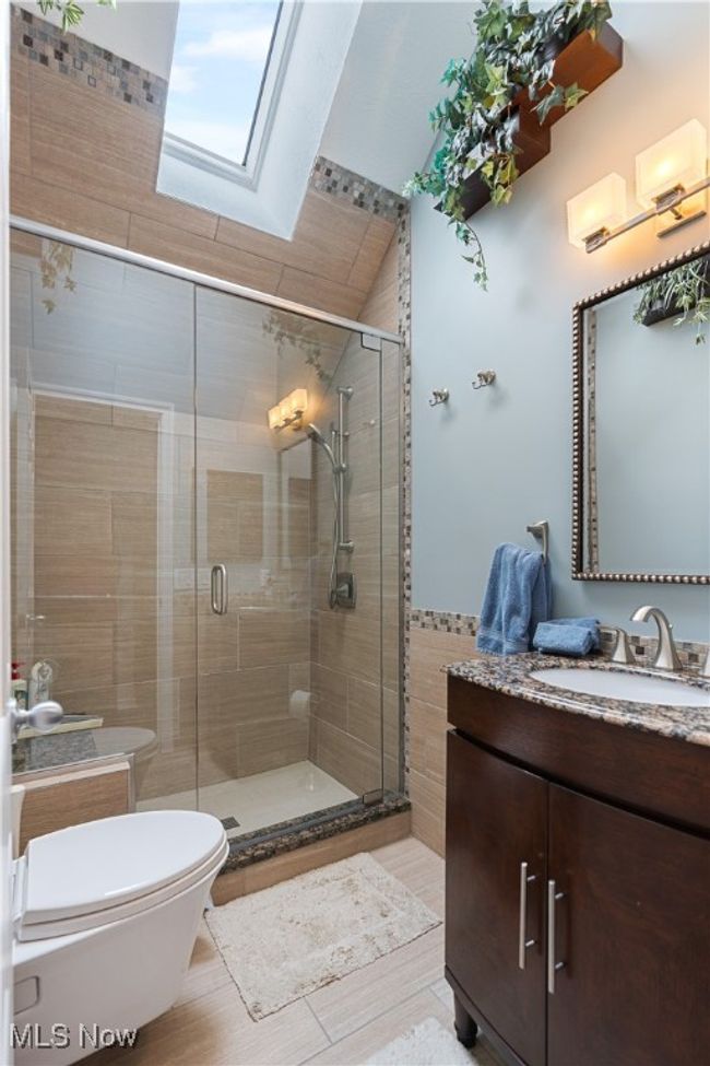 Another view one of the bathrooms with tile, high vanity and tiled shower. | Image 32
