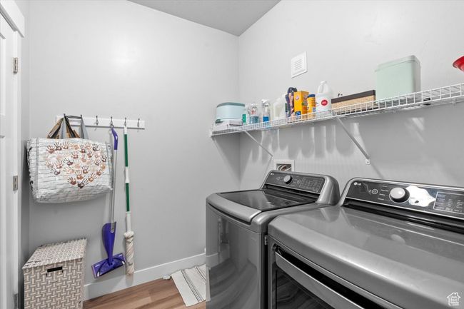 Washroom with washing machine and clothes dryer, wood finished floors, and baseboards | Image 16