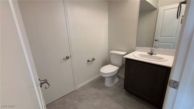 Half bath featuring toilet, tile patterned floors, and vanity | Image 5