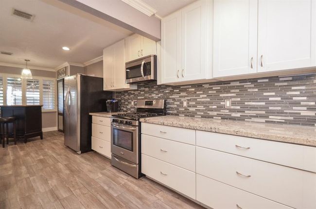 Stainless steel appliances, GAS range, tons of countertop/cabinet space and modern backsplash | Image 7