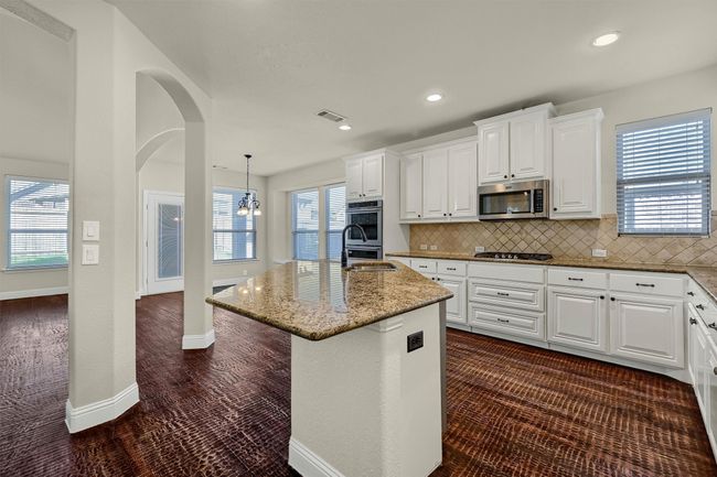 This kitchen is a chef's dream: open, spacious, and boasting ample counter space and cabinets. | Image 8