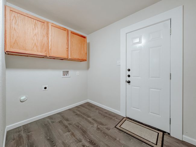 Laundry area featuring washer hookup, hookup for an electric dryer, dark wood finished floors, and cabinet space | Image 30