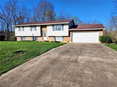 Split foyer home featuring a garage and a front lawn | Image 1