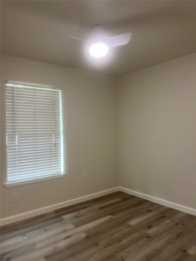Empty room featuring wood finished floors and a ceiling fan | Image 14