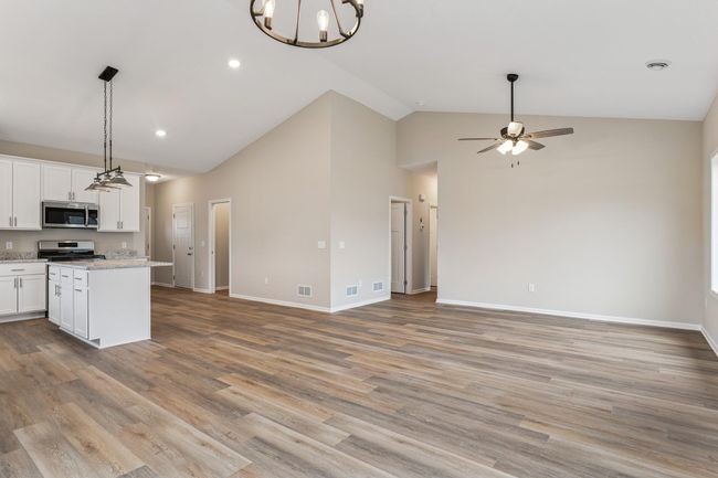 Beautiful open floor plan with walk-in pantry, island, soft close cabinetry, granite countertops and gorgeous luxury wide plank floors and vaulted ceilings. | Image 5