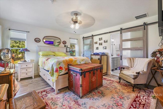 Primary bedroom, showing barn doors leading into ensuite bathroom and walk-in closet. | Image 17