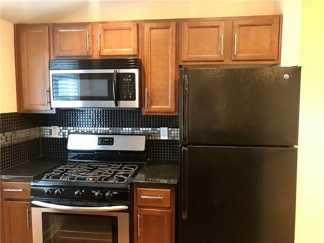 Kitchen featuring stainless steel appliances, backsplash, and brown cabinetry | Image 6