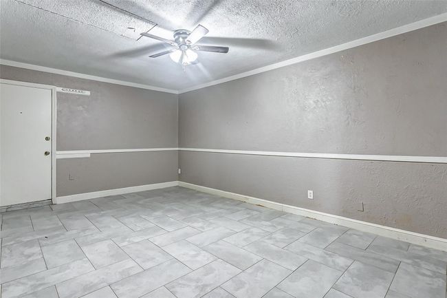 This generously sized bonus room is perfect for entertaining, a home gym, or a playroom. The clean design features fresh paint, elegant crown molding, and a ceiling fan for added comfort. A flexible area to suit your lifestyle needs, ready for customization. | Image 20