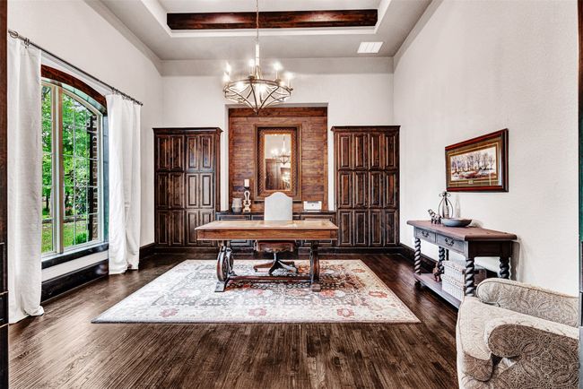 You won't want to work anywhere else than this home office! Green serene views, hardwood floors, built-in cabinets, wood accent wall and pocket doors the foyer to keep the room quiet and private when you need it. | Image 23