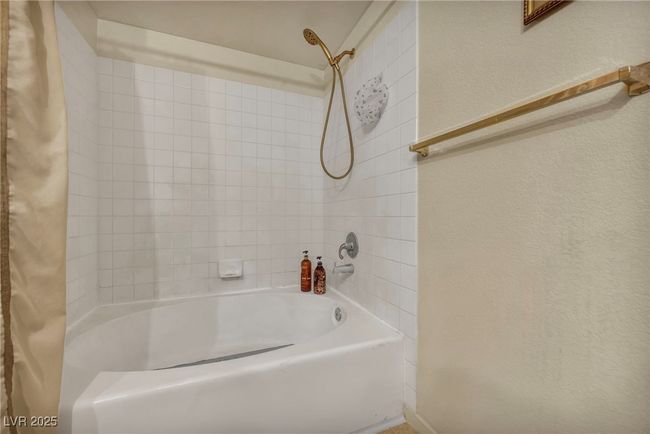 Bathroom featuring a textured wall and shower / tub combo | Image 30