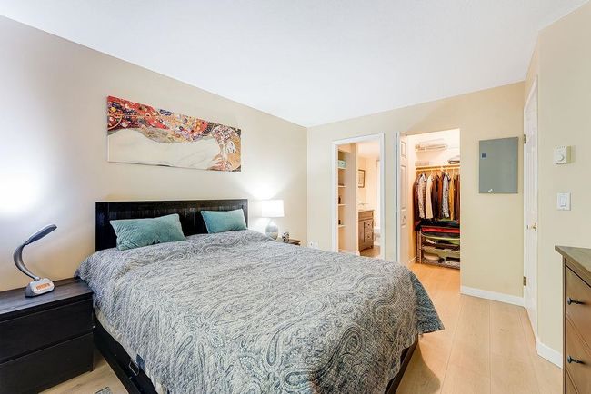 Bedroom with a walk in closet, baseboards, light wood-style flooring, a closet, and electric panel | Image 4